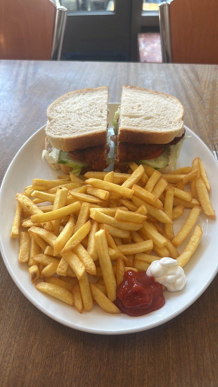 A toasted sandwich cut in half, served with chips